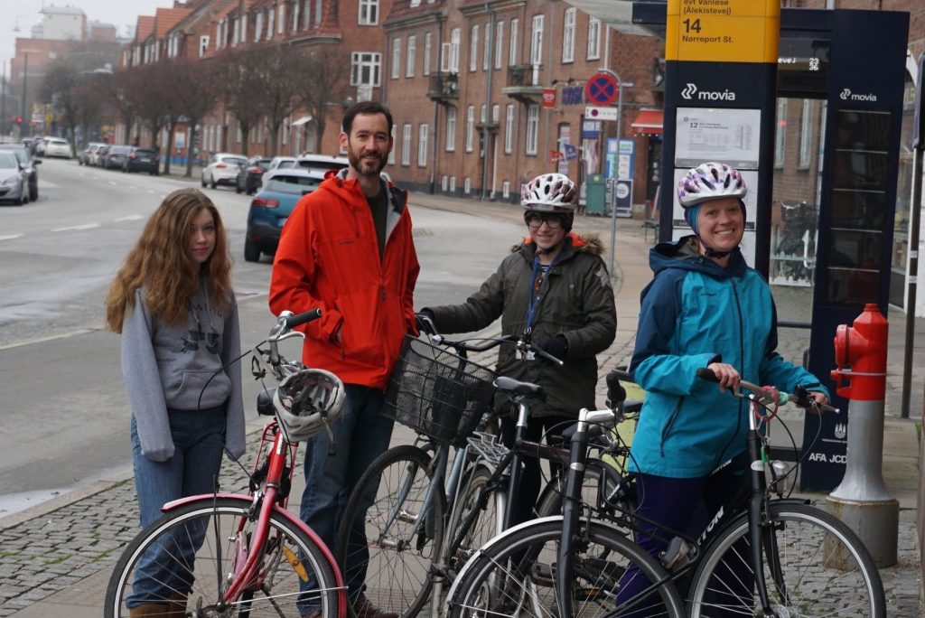 Family of four (two parents, two children) with bikes on a Copenhagen street